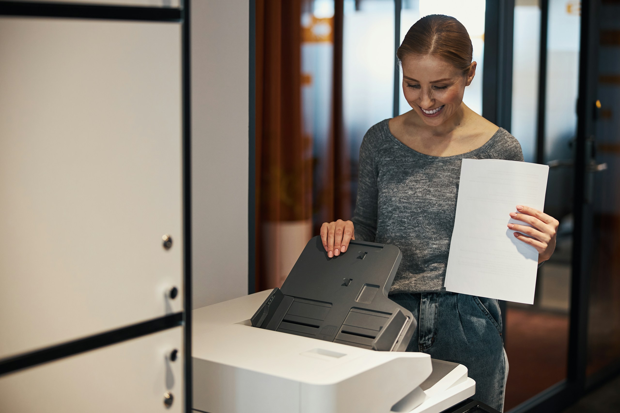 Geschäftskundin nutzt einen Multifunktionsdrucker im Büro